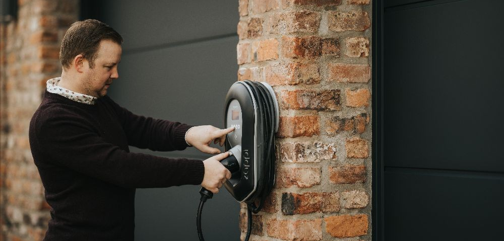 electric cars charging in house with solar panels